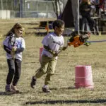 Children racing with orange toy rocket